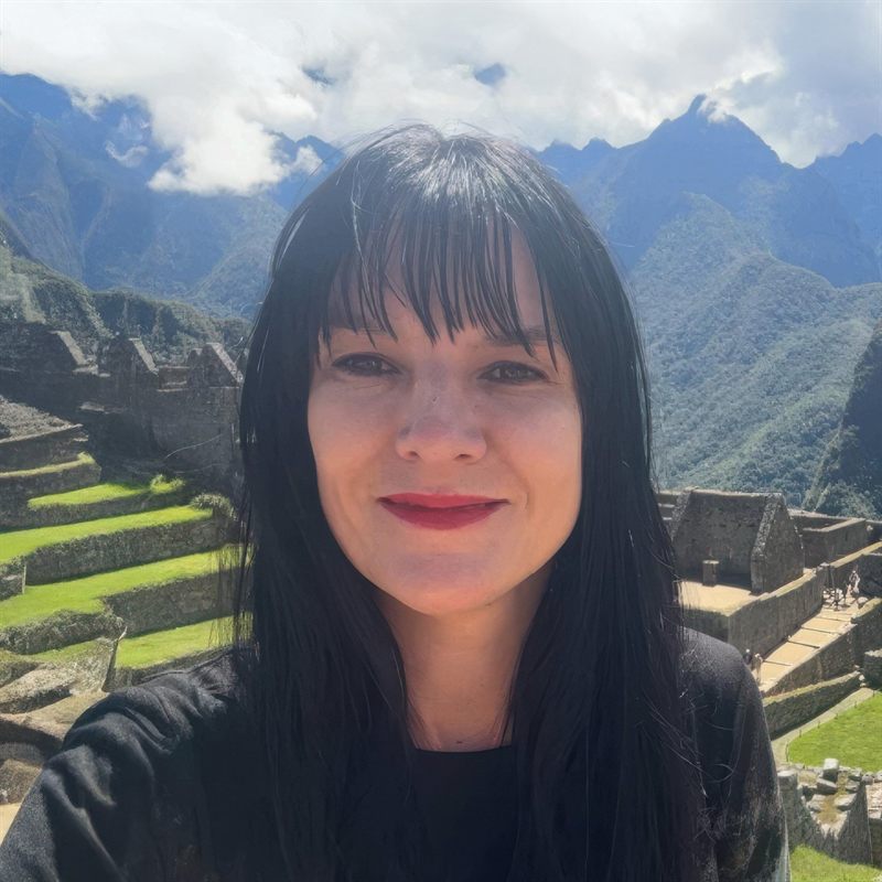 Dr Alana (Lani) Roy standing before the terraces and peaks of Machu Picchu in Peru